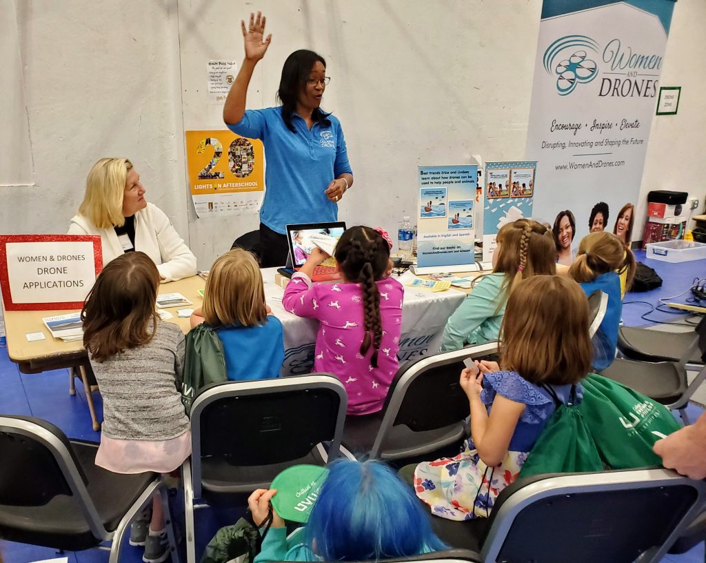 Woman teaching Girl Scouts about drones