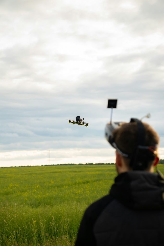 Man flying a drone over a field